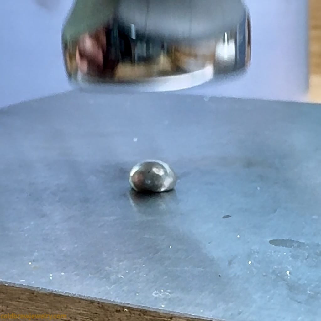 Hammering a blob of silver