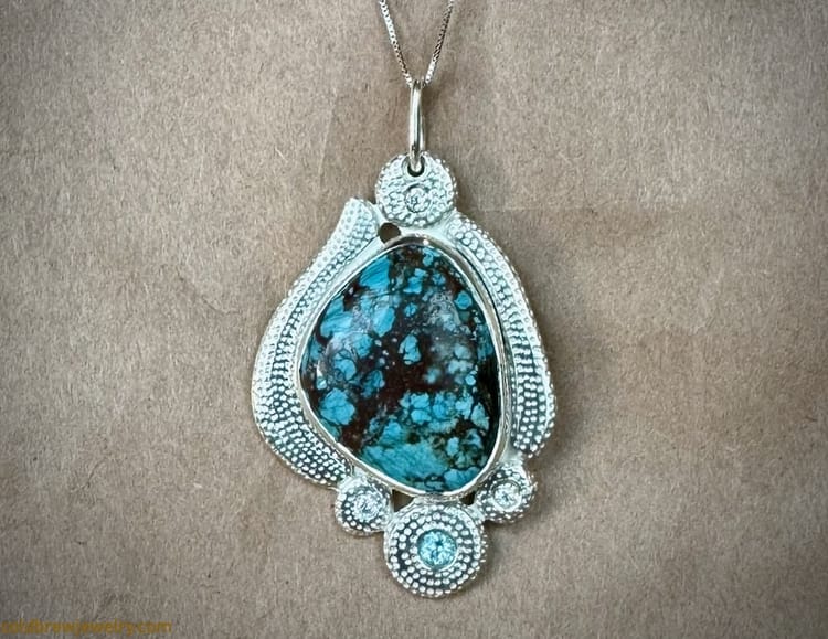 Silver pendant with a turquoise, blue topaz, and moissanites